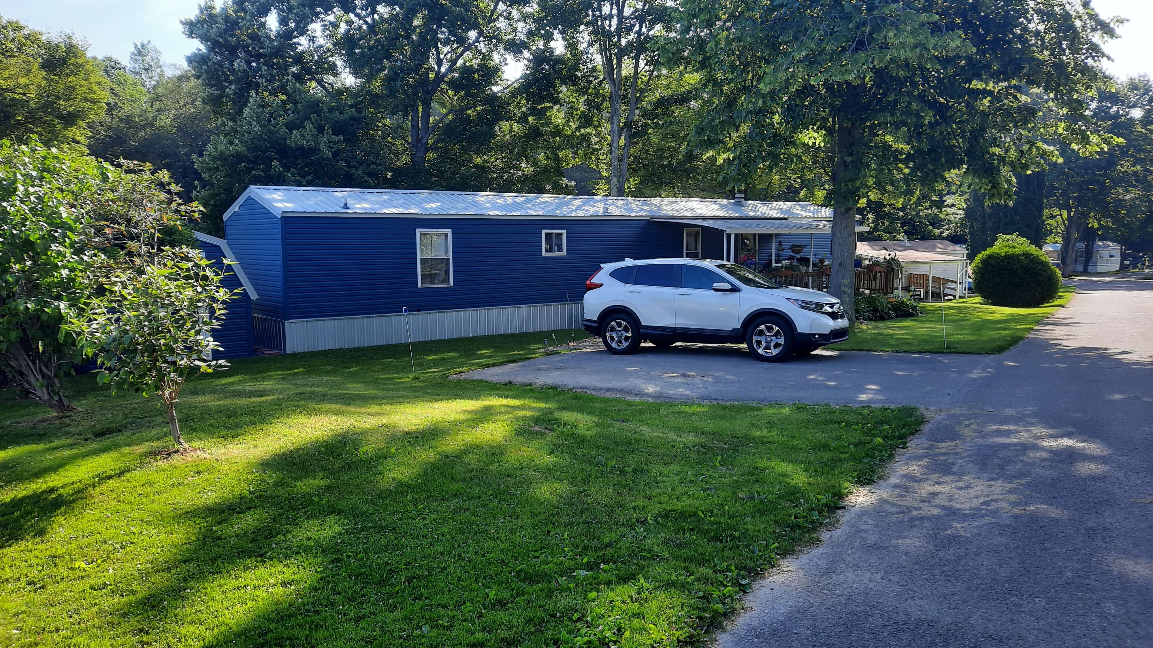 Blue mobile home with car in driveway