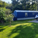 Blue mobile home with car in driveway icon