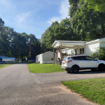 Community road with covered parking spaces and driveways icon